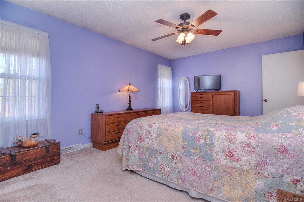 6045 Windjammer Drive Tega Cay, SC 29708 - Photo 17 of 31 a bedroom with a bed and a chandelier