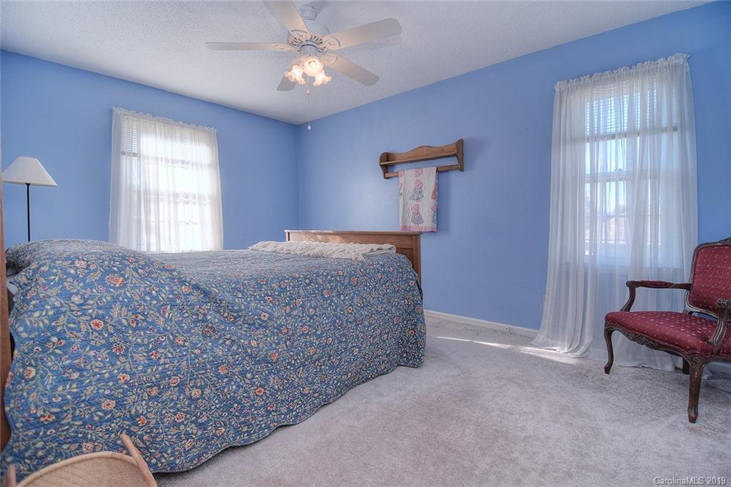 6045 Windjammer Drive Tega Cay, SC 29708 - Photo 21 of 31 a bedroom with a bed and a chair