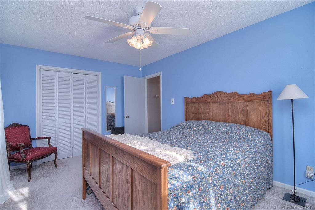 6045 Windjammer Drive Tega Cay, SC 29708 - Photo 22 of 31 a bedroom with furniture and a chandelier