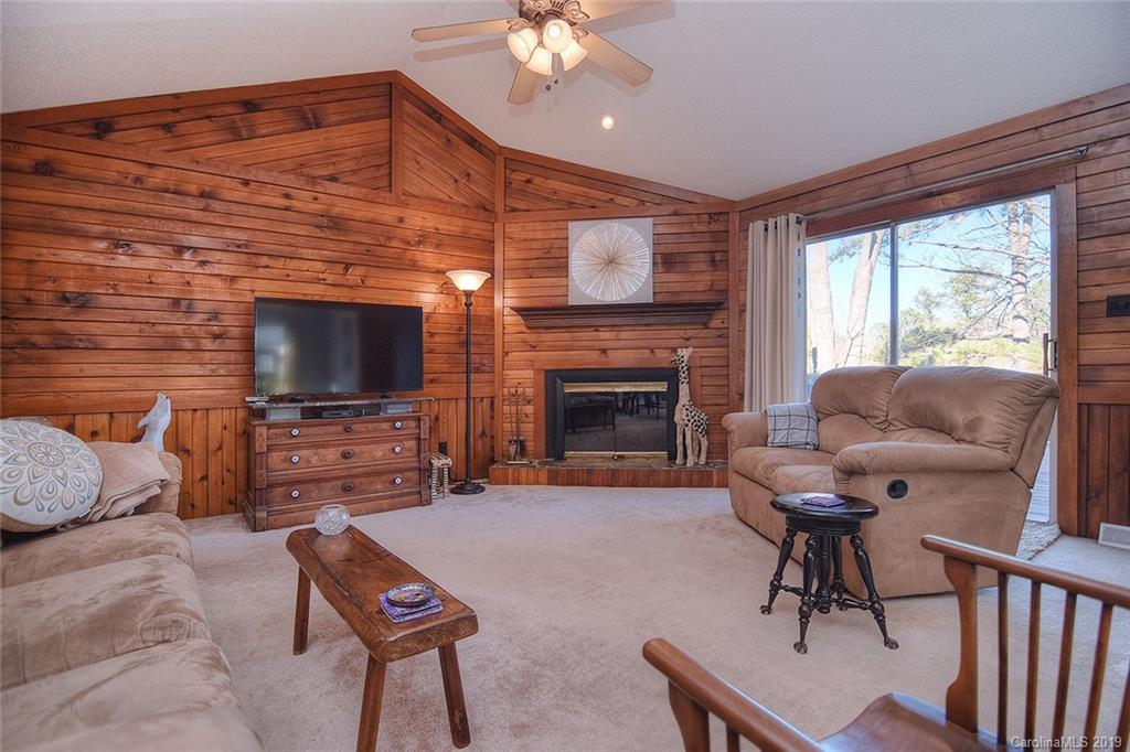6045 Windjammer Drive Tega Cay, SC 29708 - Photo 5 of 31 a living room with furniture a flat screen tv and a fireplace