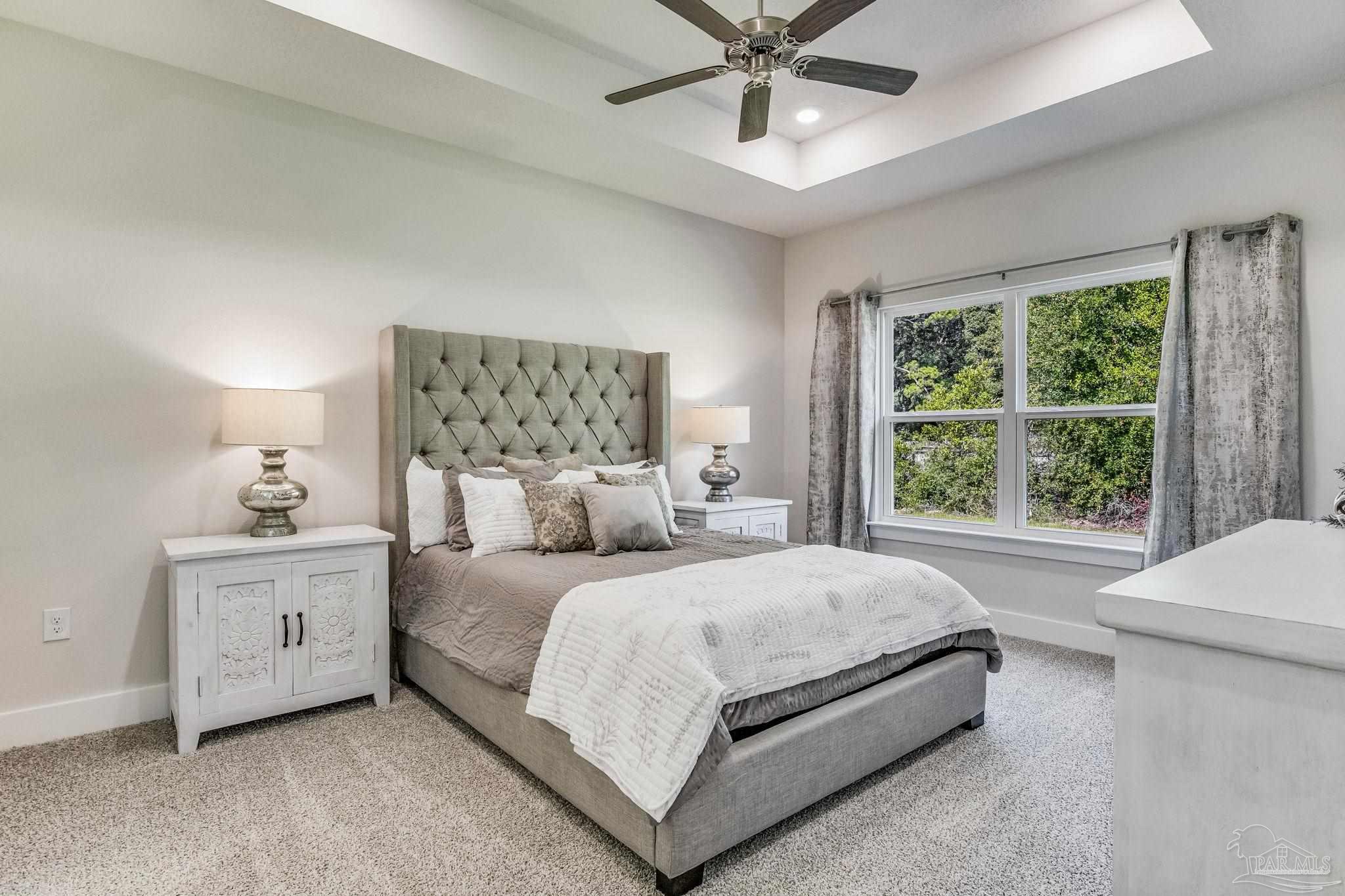 2490 Old Chemstrand Road Cantonment, FL 32533 - Photo 12 of 25 a bedroom with a large bed and a chandelier fan