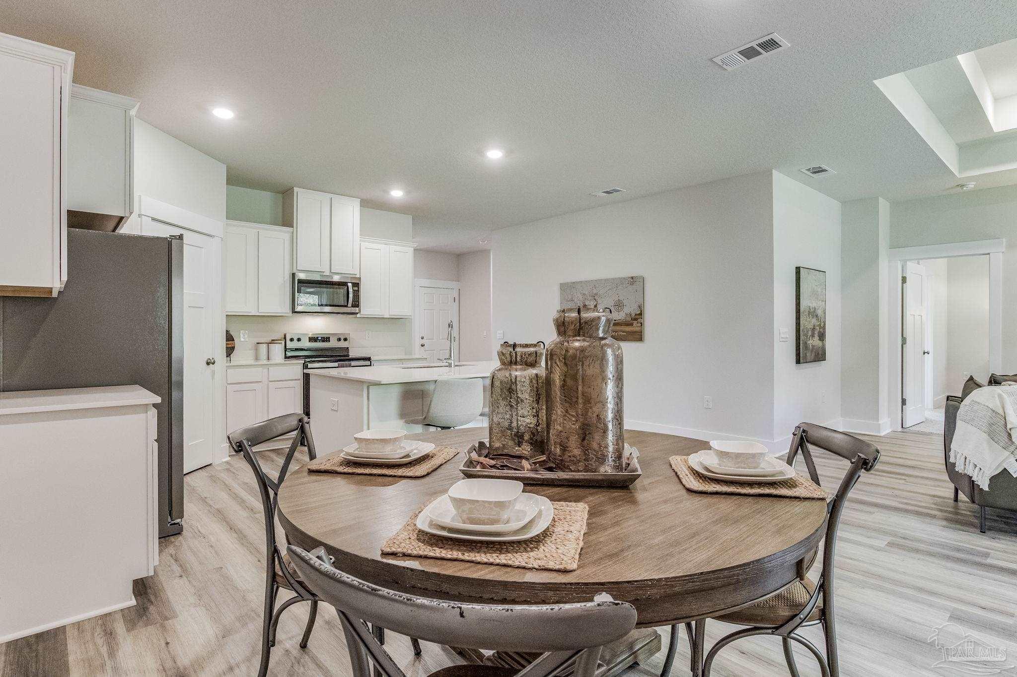 2490 Old Chemstrand Road Cantonment, FL 32533 - Photo 7 of 25 a kitchen with a dining table chairs and refrigerator