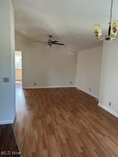 11509 Granger Road Cleveland, OH 44125 - Photo 10 of 16 Spare room featuring dark wood finished floors, a chandelier, and ceiling fan