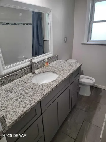 a bathroom with a granite countertop sink and a mirror