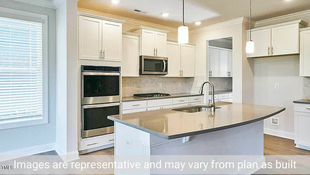 a kitchen with stainless steel appliances granite countertop a sink a stove and a refrigerator