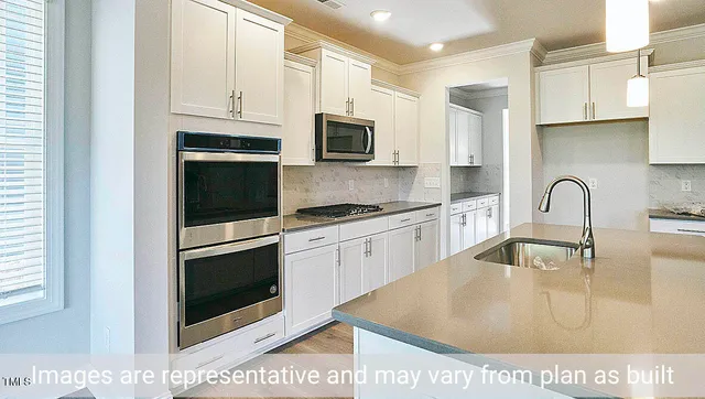 a kitchen with stainless steel appliances granite countertop a sink a stove and a microwave