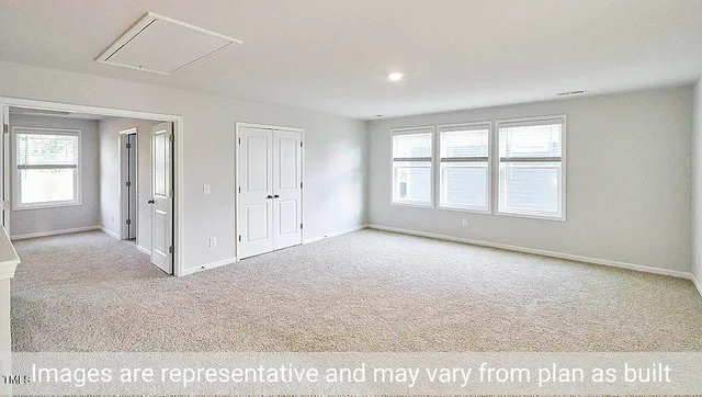 an empty room with windows and closet