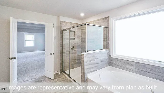 view of a bathroom with a glass door shower and a sink