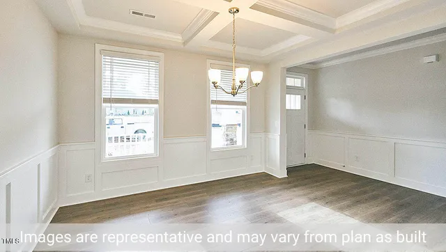 an empty room with windows and chandelier fan
