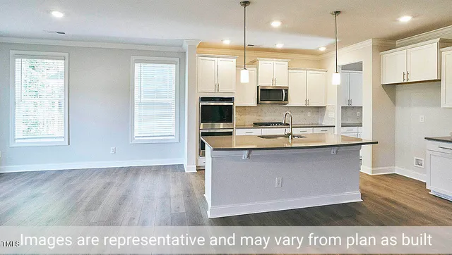 a kitchen with kitchen island granite countertop a sink cabinets and stainless steel appliances