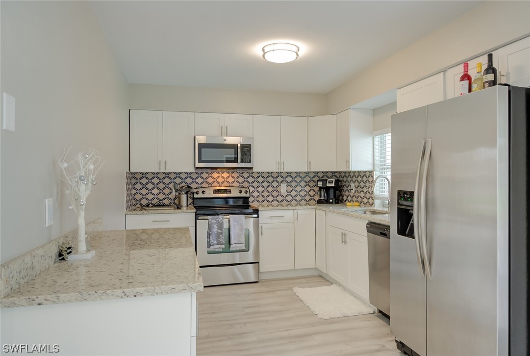 17388 Ingram Road Fort Myers, FL 33967 - Photo 6 of 18 a kitchen with white cabinets and stainless steel appliances