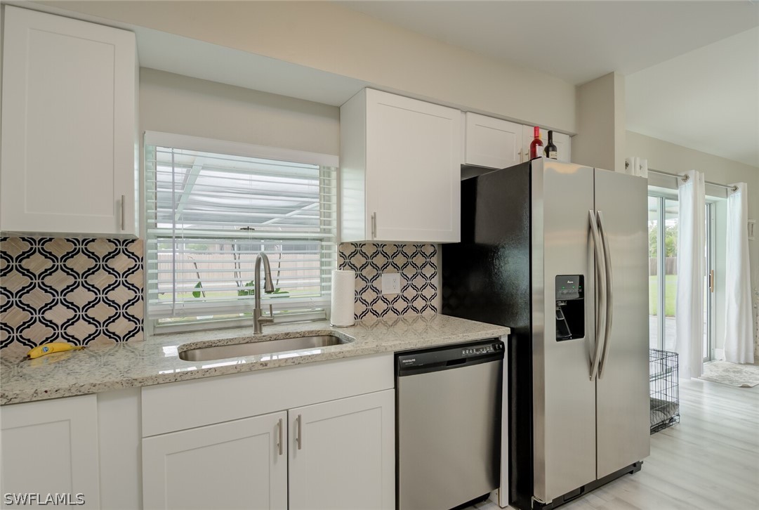 17388 Ingram Road Fort Myers, FL 33967 - Photo 7 of 18 a kitchen with stainless steel appliances granite countertop a refrigerator and a sink