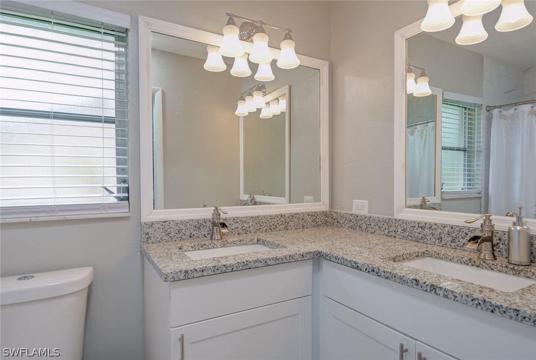 17388 Ingram Road Fort Myers, FL 33967 - Photo 10 of 18 a bathroom with a granite countertop sink a large mirror and a toilet
