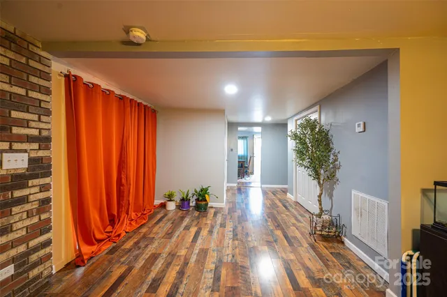 a view of a room with wooden floor and potted plant