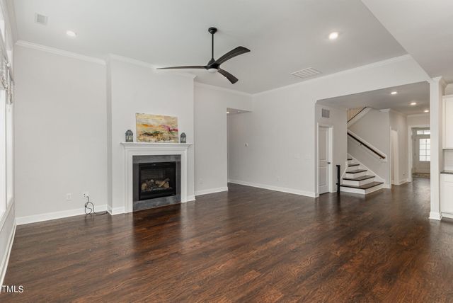 a view of an empty room with wooden floor a fireplace