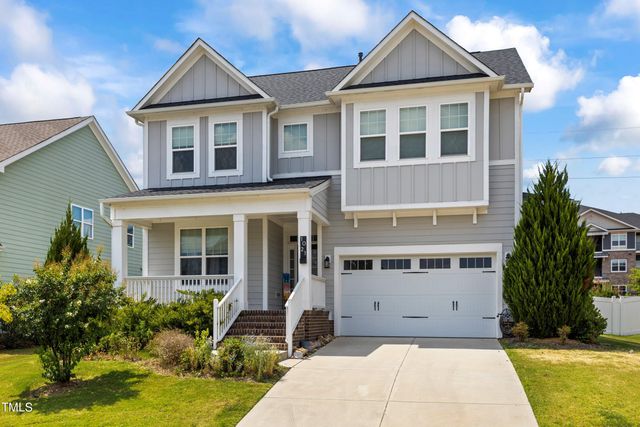 a front view of a house with a yard and potted plants