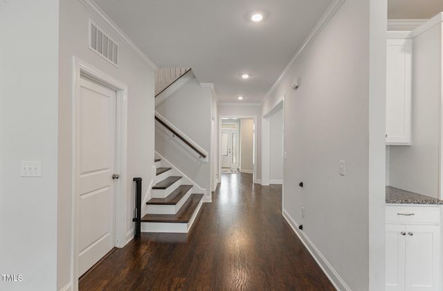 a view of a hallway with wooden floor and staircase