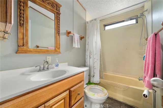 a bed sitting in a spacious bedroom next to a window