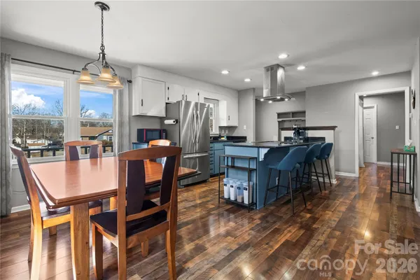 a dining room with furniture a chandelier and wooden floor