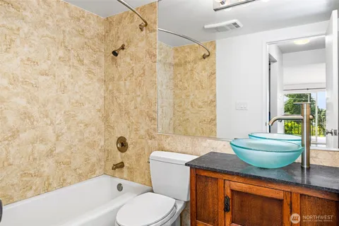 a bathroom with a granite countertop toilet a sink and a bathtub