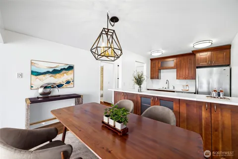 a dining room with wooden floor a chandelier a wooden table and chairs