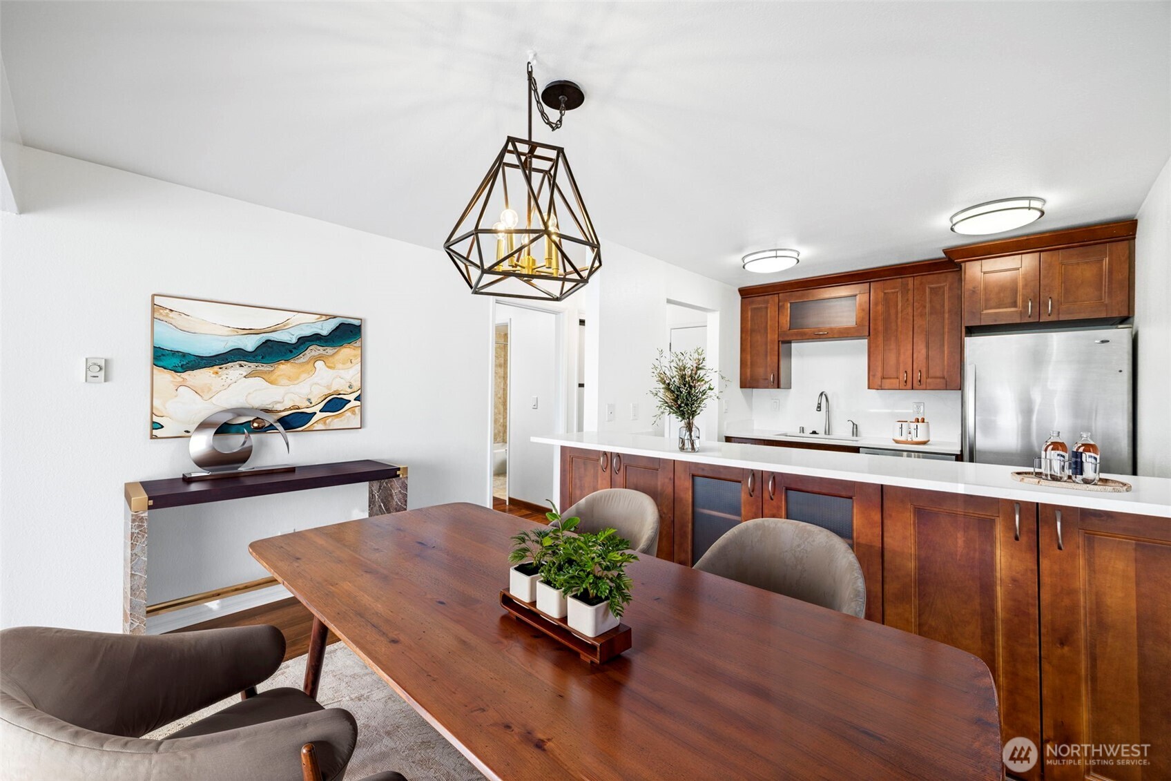 3601 24th Avenue West, Unit 207 Seattle, WA 98199 - Photo 6 of 24 a dining room with wooden floor a chandelier a wooden table and chairs