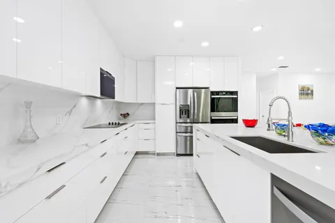 a kitchen with granite countertop a sink and white stainless steel appliances
