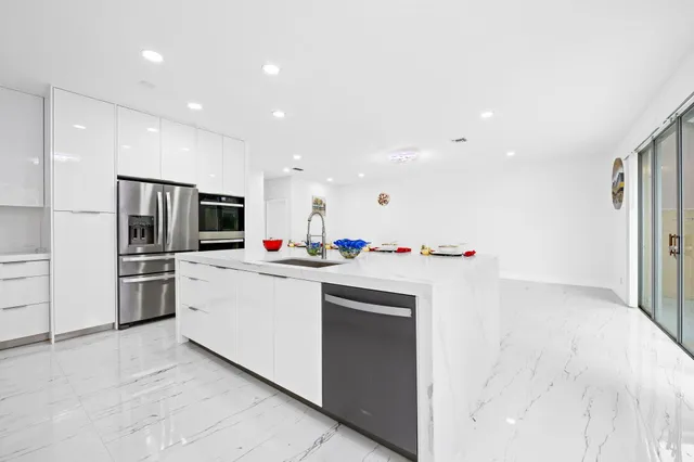 a kitchen with stainless steel appliances kitchen island sink refrigerator and microwave
