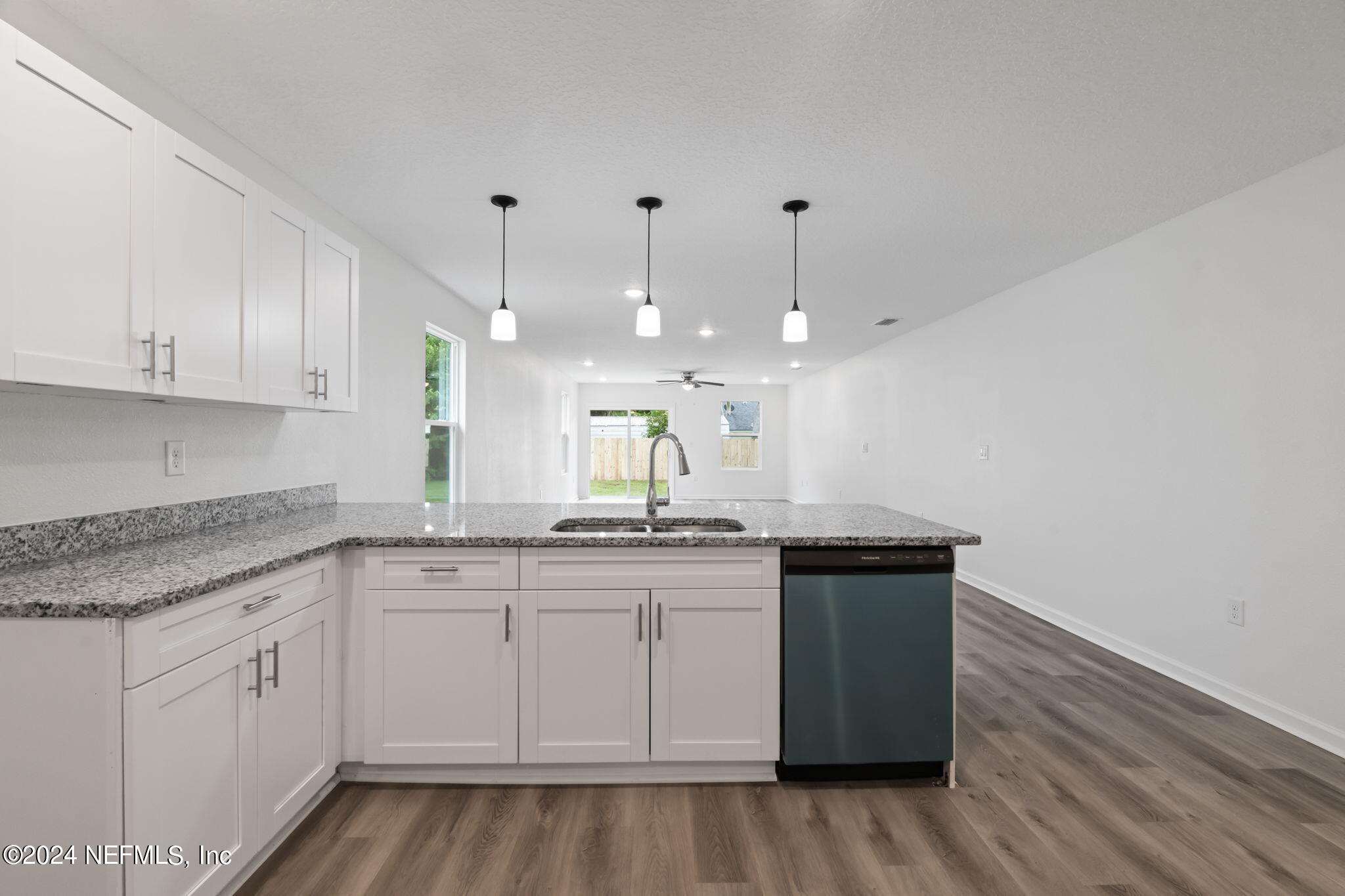 1014 Floyd Street Fleming Island, FL 32003 - Photo 11 of 48 a kitchen with granite countertop white cabinets and a wooden floor