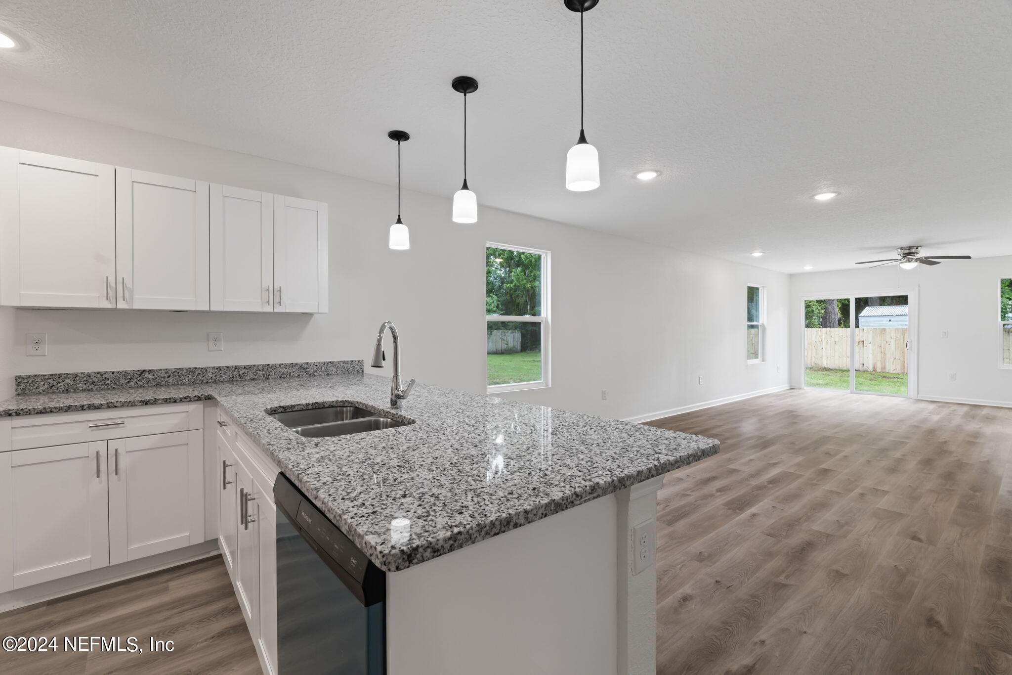 1014 Floyd Street Fleming Island, FL 32003 - Photo 12 of 48 a kitchen with granite countertop kitchen island a sink stainless steel appliances and white cabinets