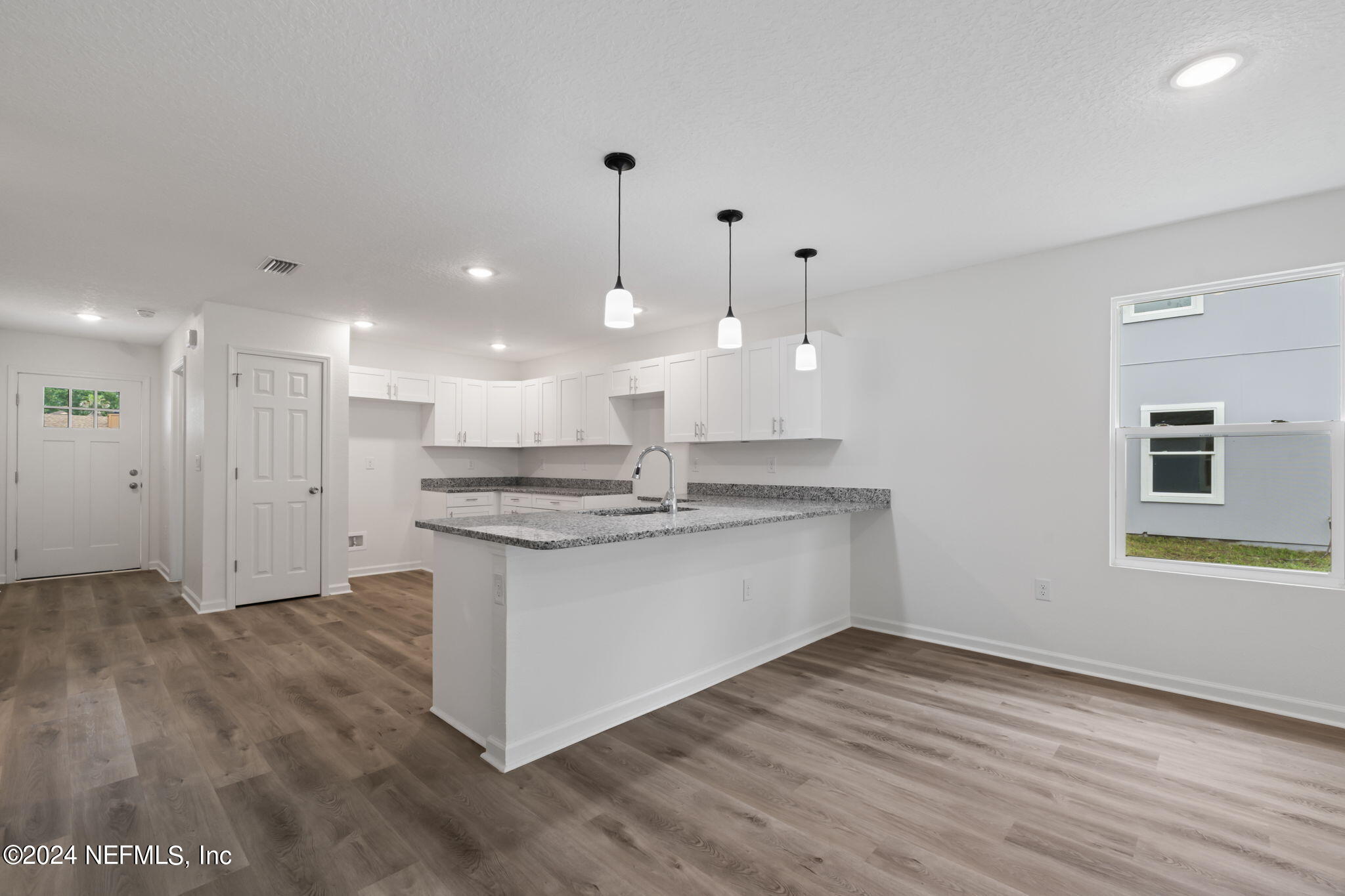 1014 Floyd Street Fleming Island, FL 32003 - Photo 13 of 48 a view of kitchen with granite countertop sink refrigerator and white cabinets