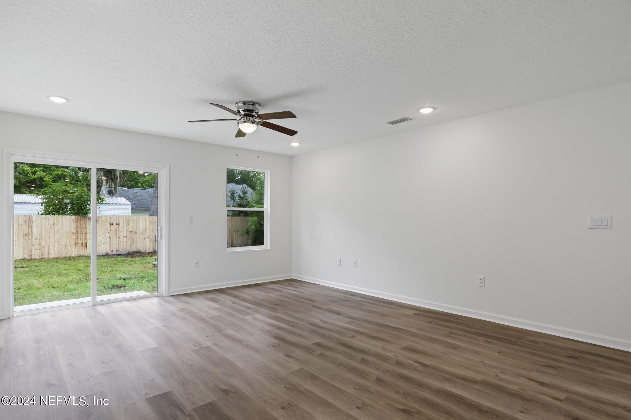 1014 Floyd Street Fleming Island, FL 32003 - Photo 20 of 48 a view of a livingroom with a hardwood floor and a ceiling fan