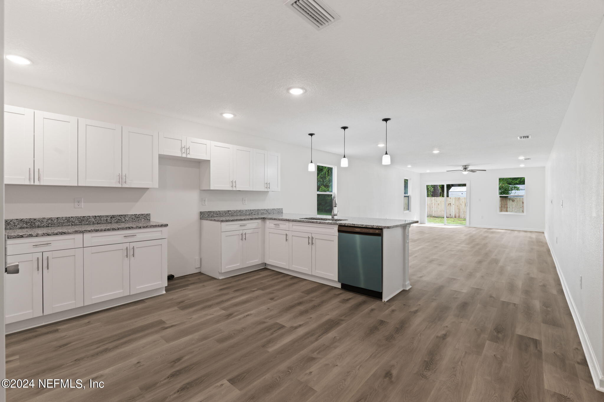 1014 Floyd Street Fleming Island, FL 32003 - Photo 8 of 48 a large kitchen with kitchen island a sink white cabinets and stainless steel appliances