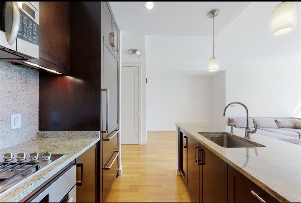 400 Stuart Street, Unit 18G Boston, MA 02116 - Photo 6 of 20 a kitchen with stainless steel appliances a sink stove and cabinets