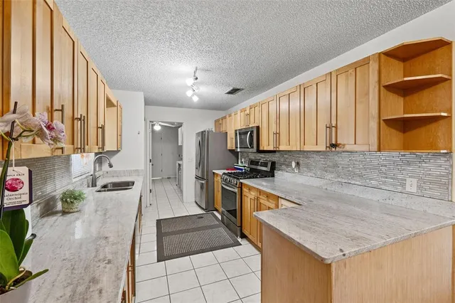 a large kitchen with granite countertop a sink and a stove