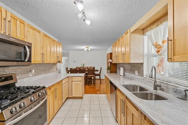 a kitchen with stainless steel appliances a sink a stove and cabinets