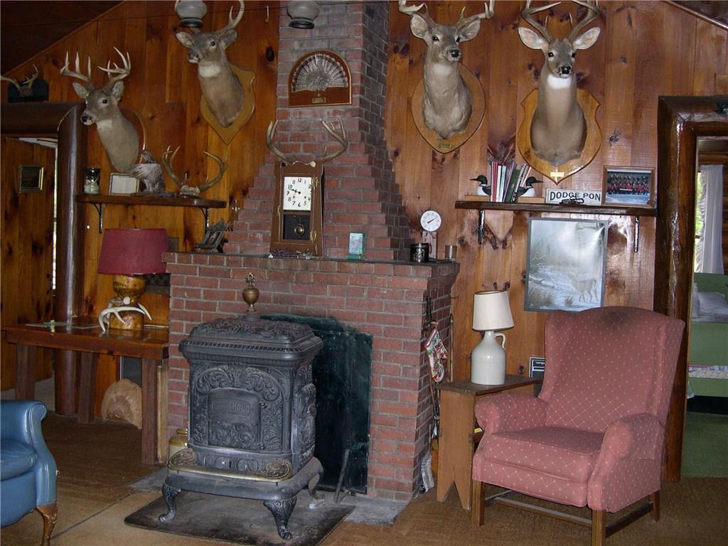 279 Dodge Pond Road, Unit 5 Rangeley, ME 04970 - Photo 5 of 35 antique parlor stove and brick fireplace
