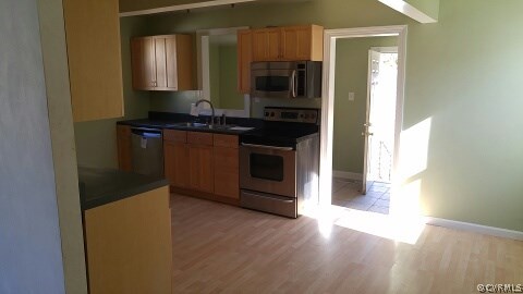 25 Warner Road Hampton, VA 23666 - Photo 4 of 11 a kitchen with granite countertop a refrigerator and a stove top oven