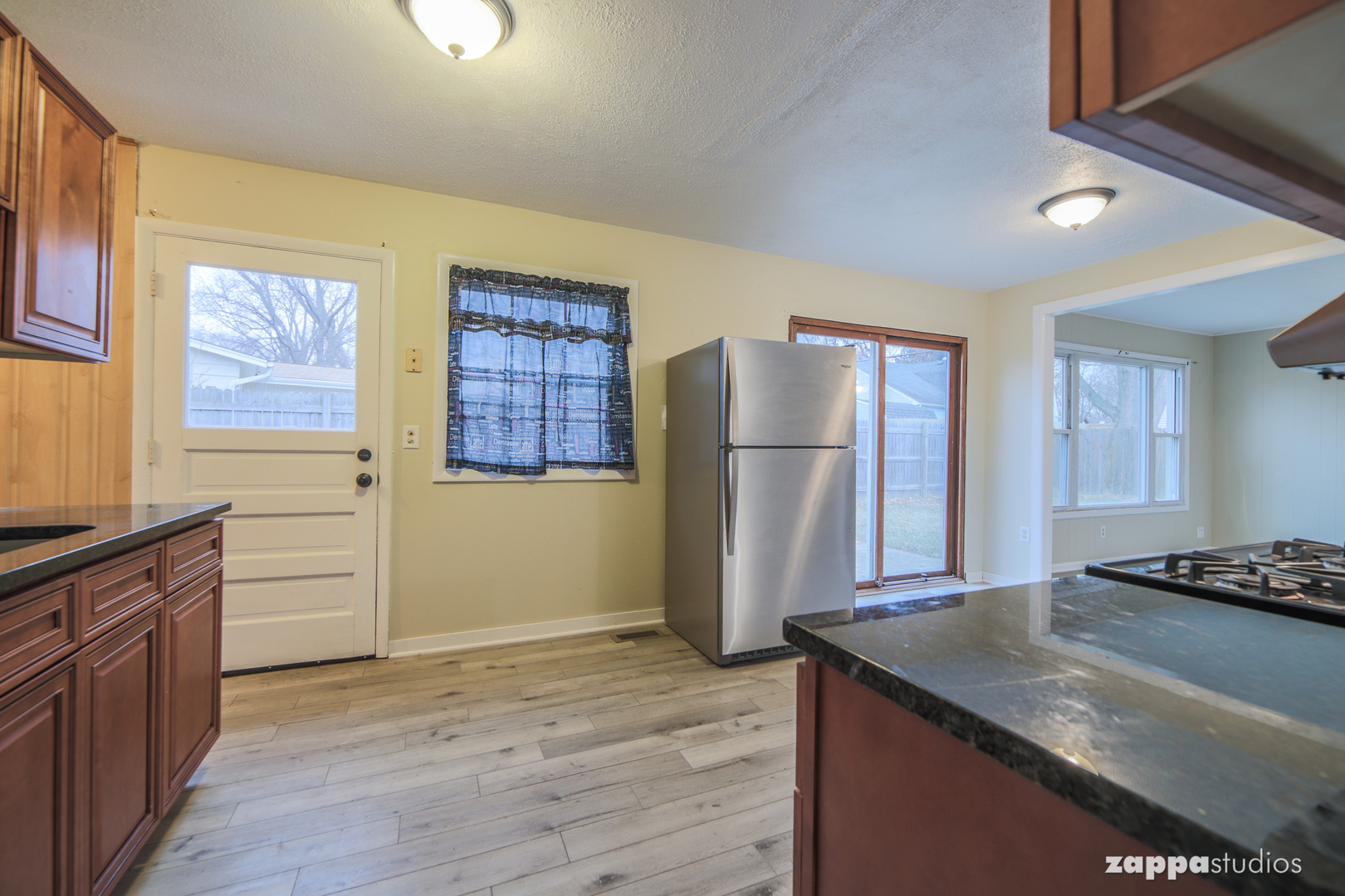 58 Long Beach Road Montgomery, IL 60538 - Photo 11 of 35 a kitchen with granite countertop a refrigerator and a stove top oven