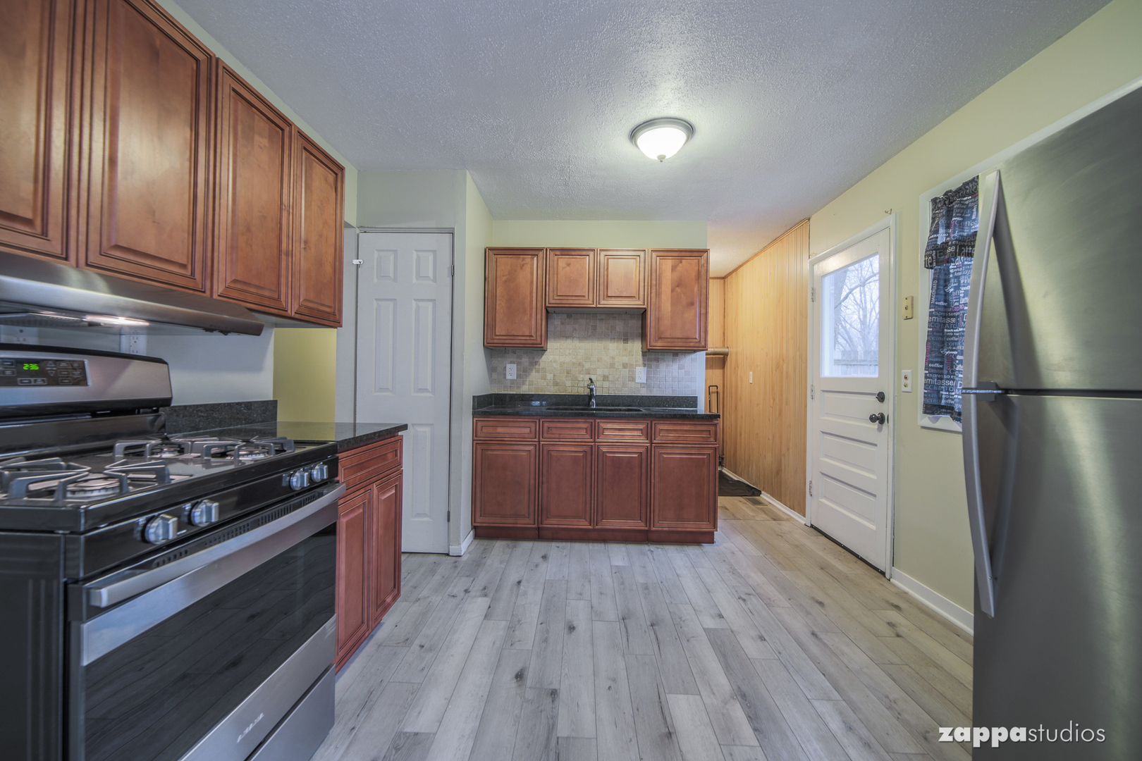 58 Long Beach Road Montgomery, IL 60538 - Photo 12 of 35 a kitchen with stainless steel appliances granite countertop wooden floors wooden cabinets and sink