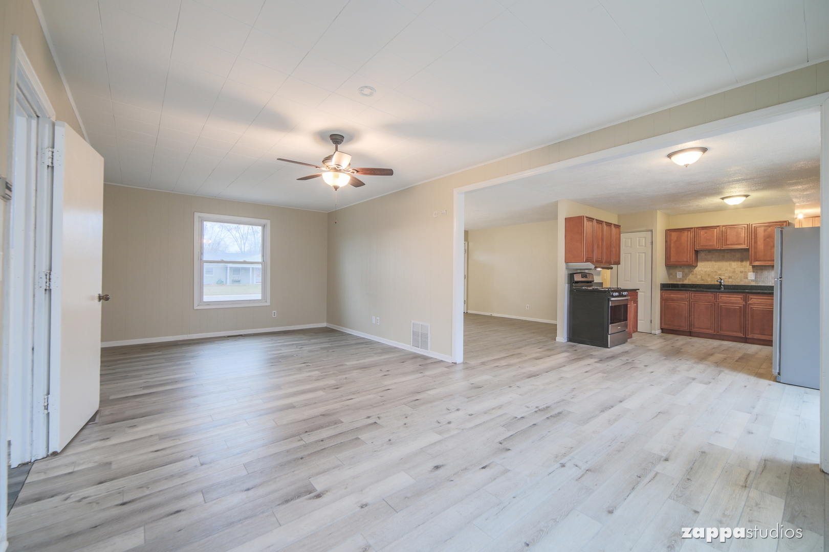 58 Long Beach Road Montgomery, IL 60538 - Photo 16 of 35 a view of an empty room with a kitchen and wooden floor