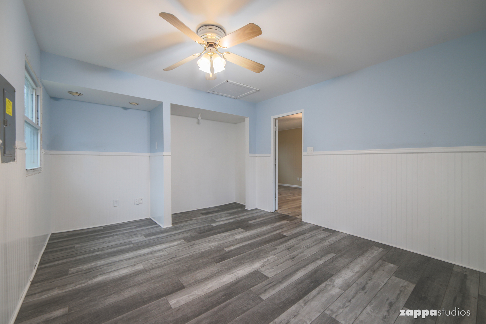 58 Long Beach Road Montgomery, IL 60538 - Photo 21 of 35 a view of an empty room with chandelier fan and wooden floor