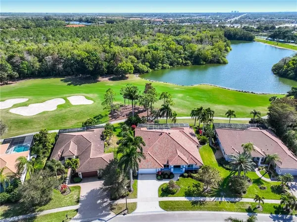 an aerial view of residential houses with outdoor space and lake view