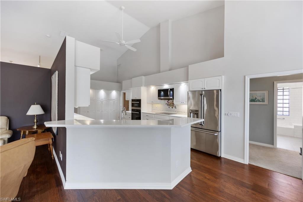 8992 Lely Island Circle Naples, FL 34113 - Photo 16 of 42 a kitchen with stainless steel appliances a refrigerator and a stove top oven