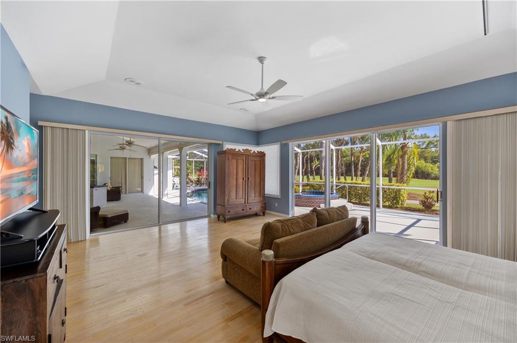 8992 Lely Island Circle Naples, FL 34113 - Photo 21 of 42 a spacious bedroom with a large bed and a large window