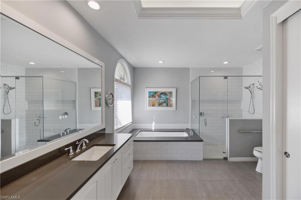8992 Lely Island Circle Naples, FL 34113 - Photo 22 of 42 a spacious bathroom with a large tub shower and sink