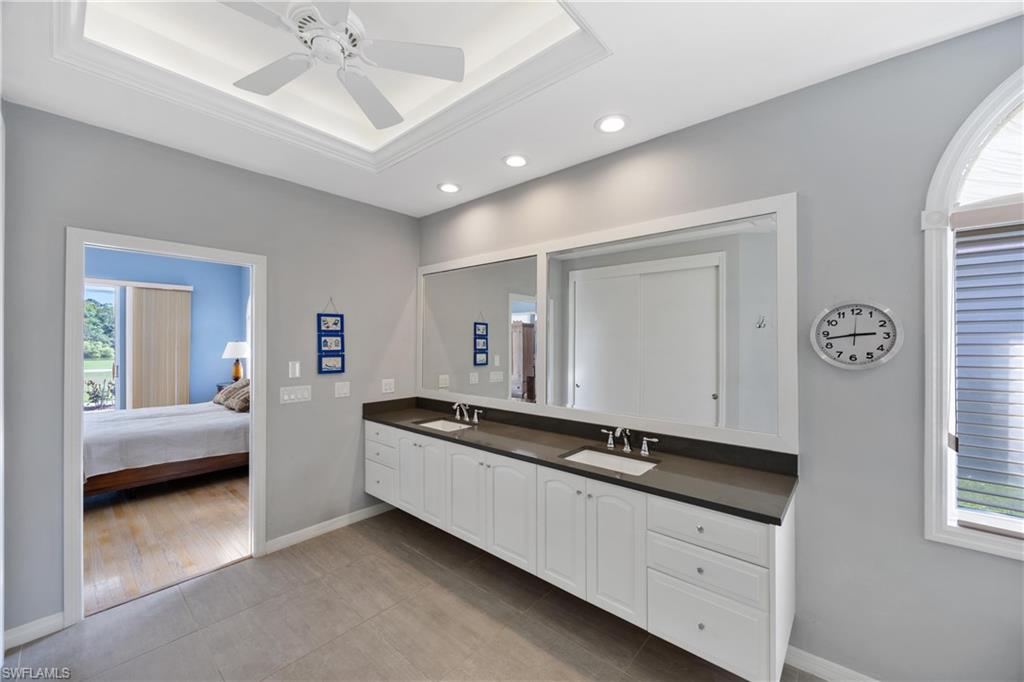 8992 Lely Island Circle Naples, FL 34113 - Photo 23 of 42 a spacious bathroom with a double vanity sink and a mirror