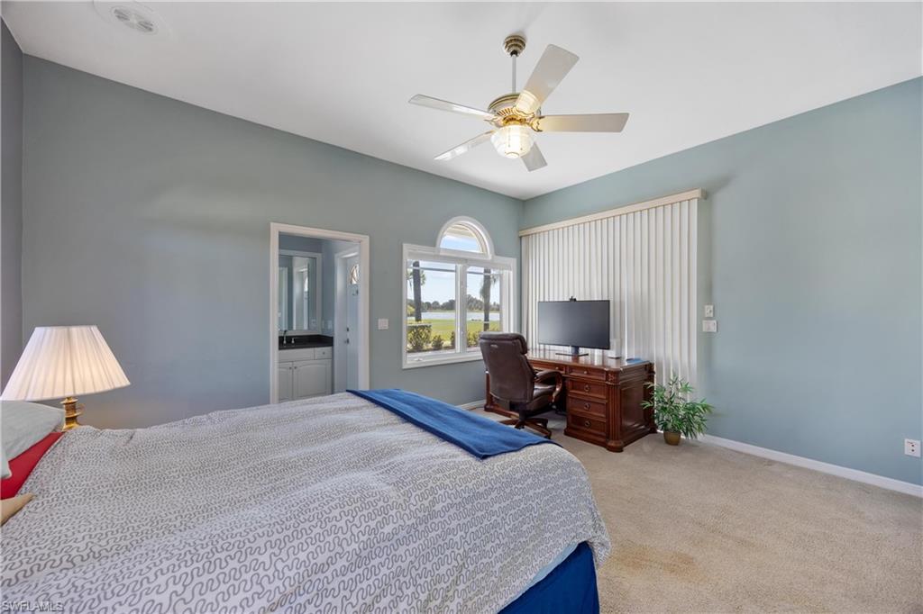 8992 Lely Island Circle Naples, FL 34113 - Photo 27 of 42 a bedroom with a large bed and a chandelier