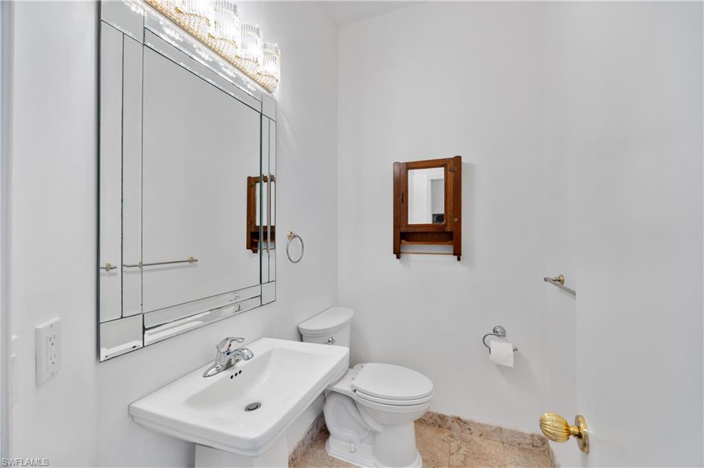 8992 Lely Island Circle Naples, FL 34113 - Photo 30 of 42 a bathroom with a sink mirror and toilet