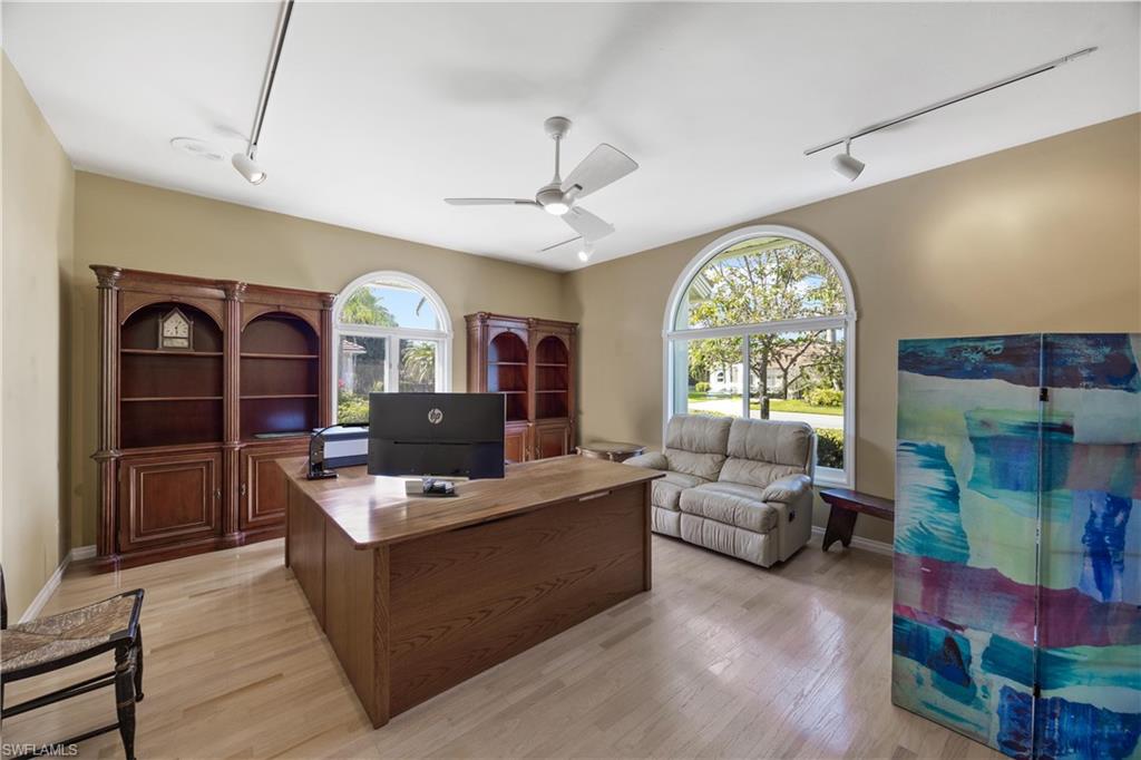8992 Lely Island Circle Naples, FL 34113 - Photo 31 of 42 a living room with furniture a fireplace and a chandelier